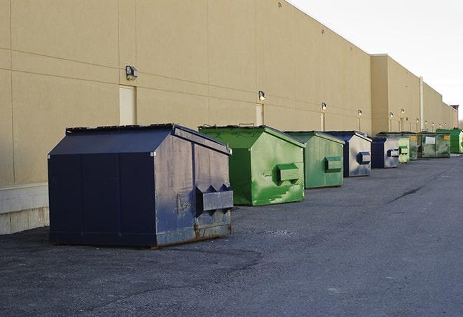 a fleet of red and blue construction dumpsters available for use in Gautier, MS